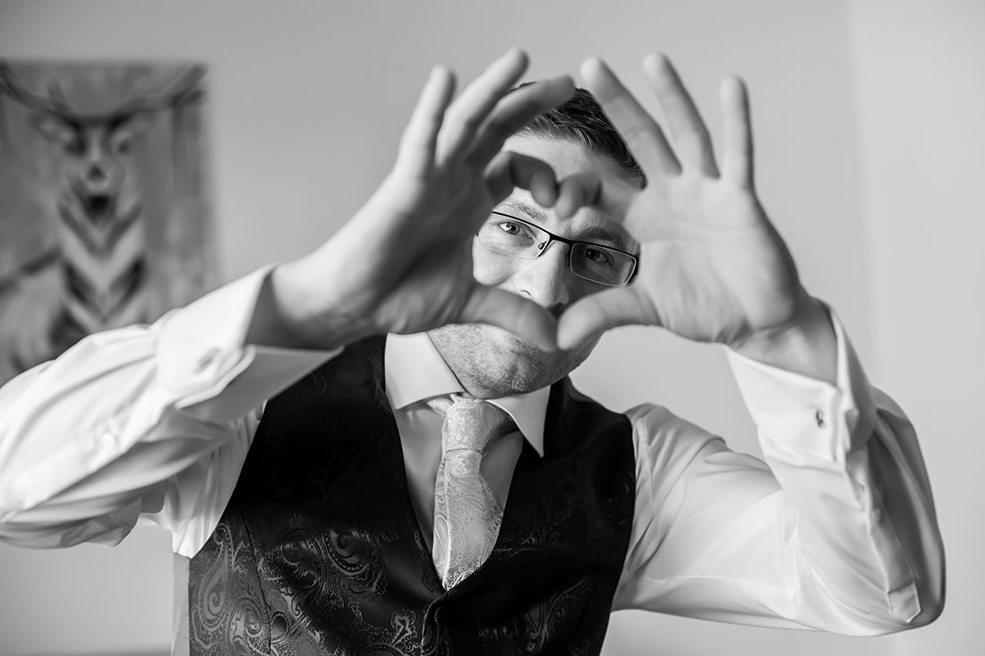 Hochzeit-in-Braunschweig-Bräutigam-getting-ready-Herz-aus-Händen-Spaß-lustiges-Foto-Manschettenknöpfe-schwarz-weis-Sergej-Metzger-Hochzeitsvideo-Hannover-Fotograf-Hildesheim