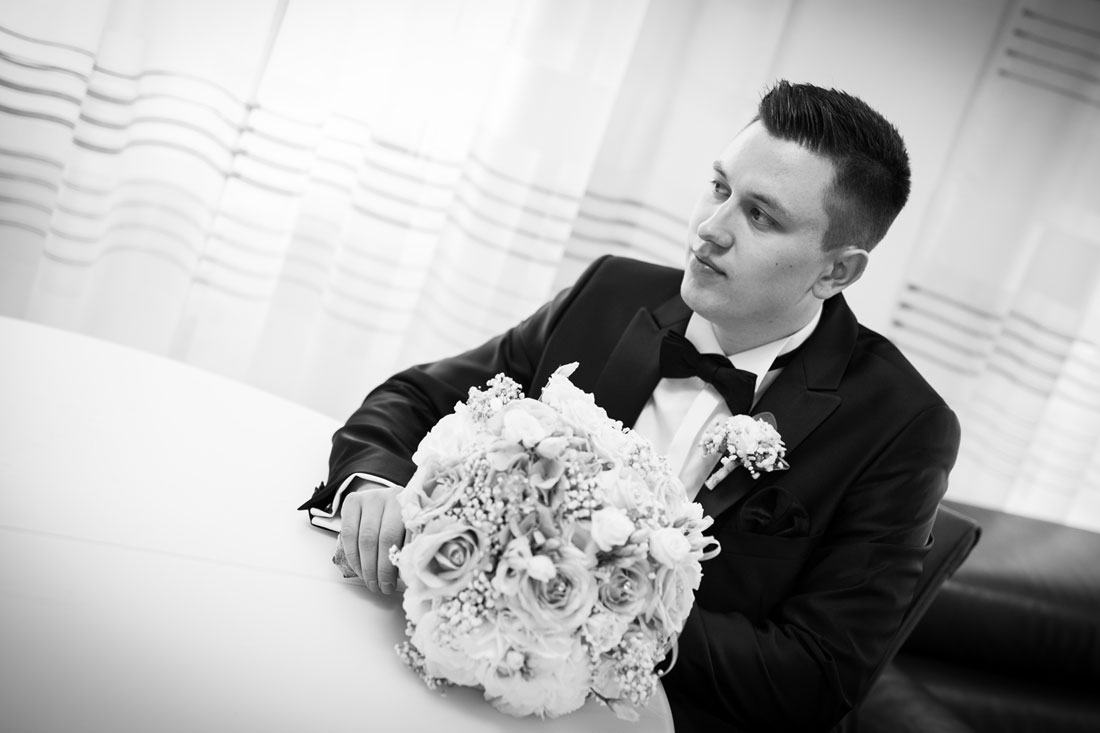natalja-frei-hochzeitsfotograf-braeutigam-mit-blumenstrauss-braeutigamtvorbereitung-getting-ready-hochzeit-fotograf-hildesheim-schwarz-weis-hannover-hildesheim-goslar-salzgitter-eschershausen