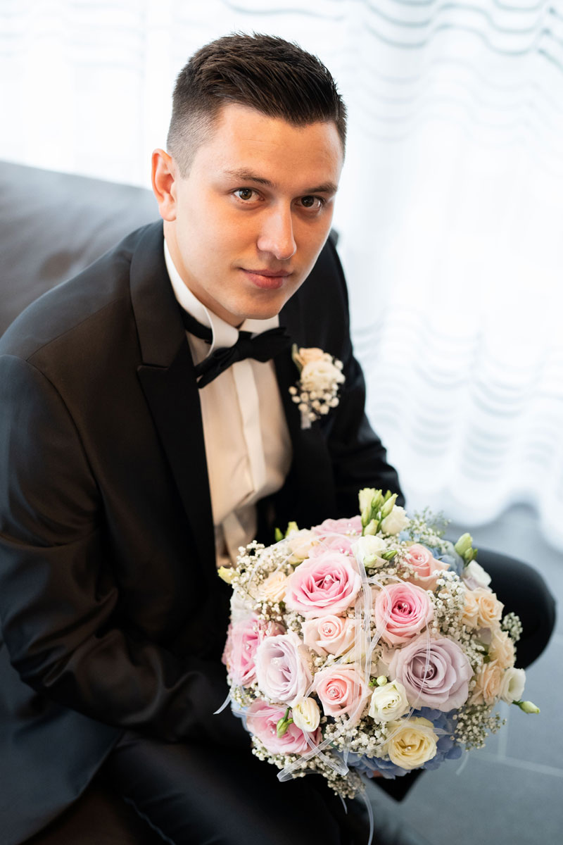 atalja-frei-hochzeitsfotograf-braeutigam-mit-blumenstrauss-braeutigamtvorbereitung-getting-ready-hochzeit-fotograf-hannover-hildesheim-gifhorn-celle-salzgitter-mannheim-man